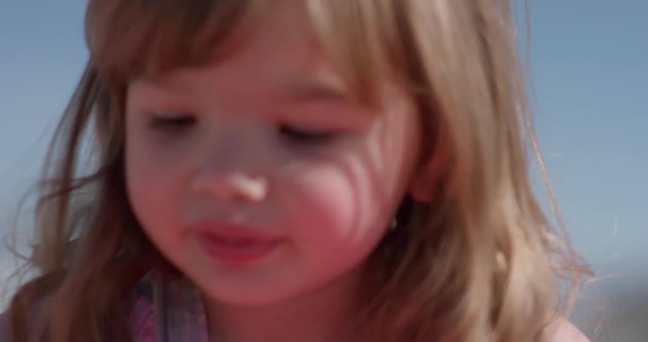 Girl plays with sand at the beach
