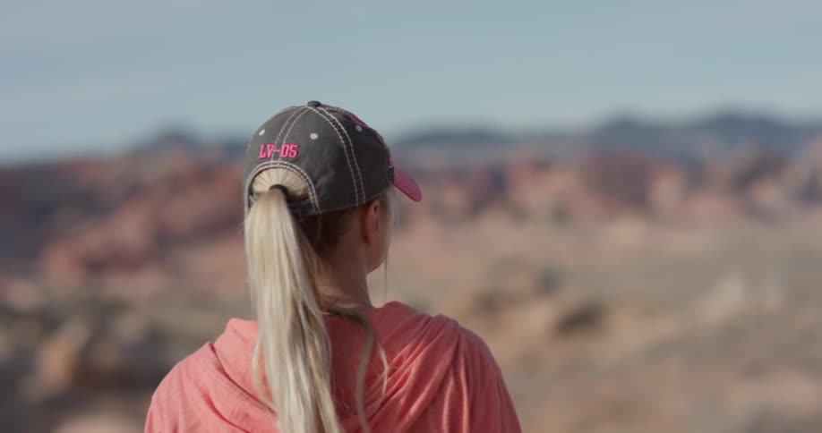 A woman stands alone in a desert