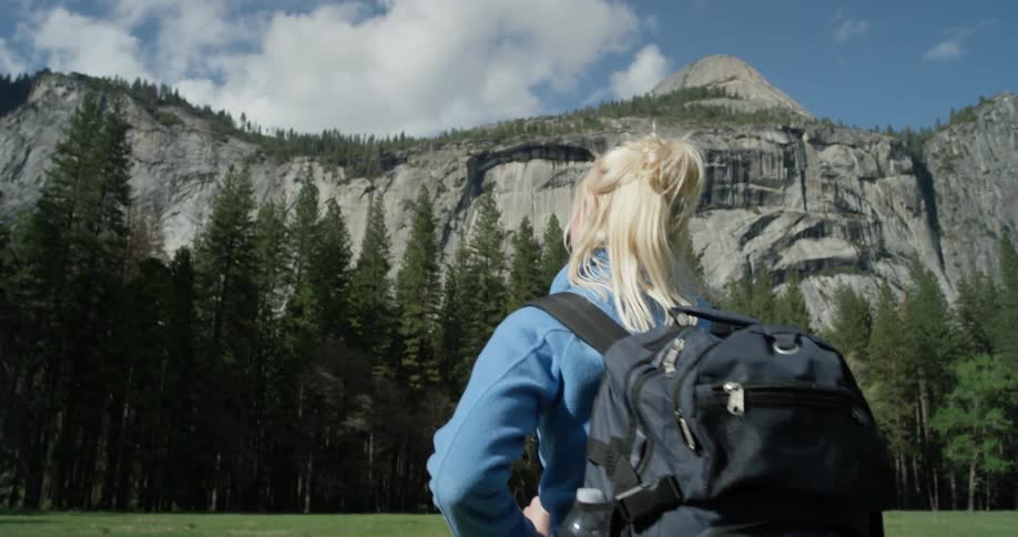 A woman hikes towards the tall mountain