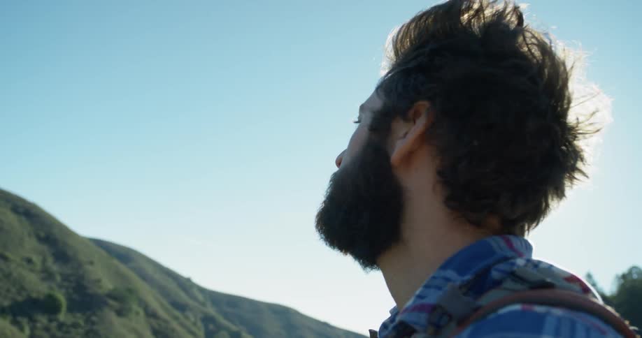 A hiker looks around at the mountains