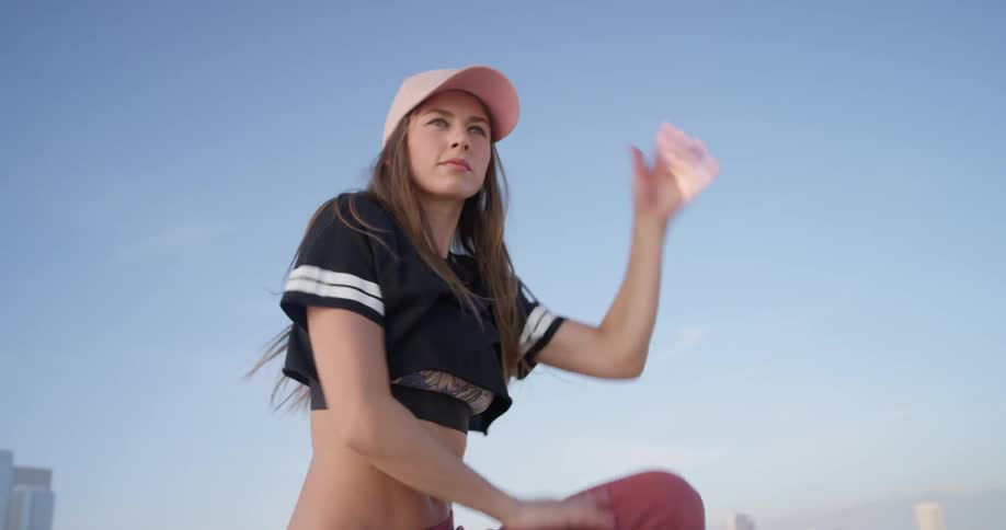 A woman dances on a building rooftop