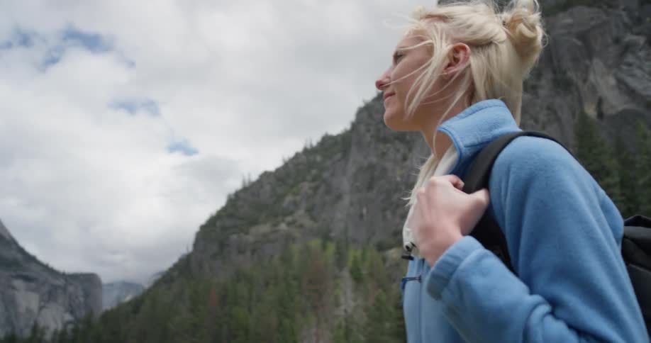 A woman smiles as she looks up at the cliffs