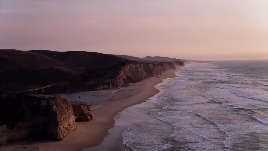 Rough waves hit the shore at sunset