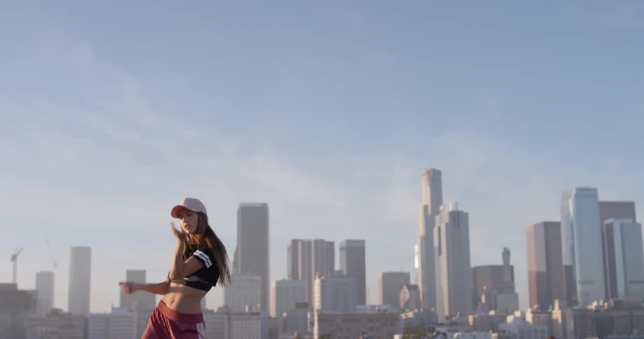 A woman dances on a building rooftop