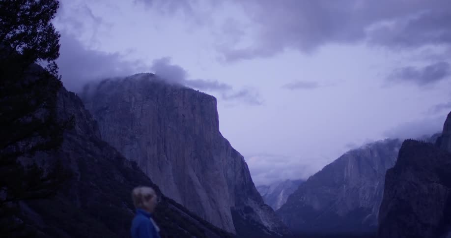 The woman watches the mountain range on a cloudy day