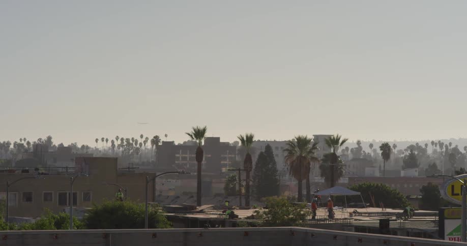 People stand on a building rooftop in a city