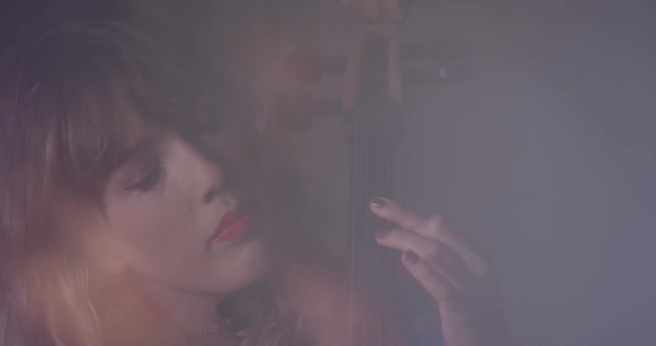 A woman is playing a cello inside in daylight