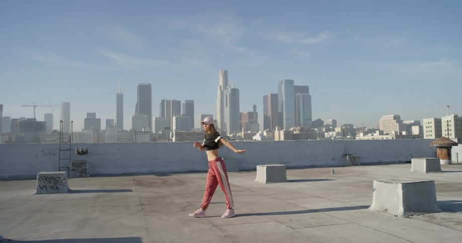 A woman dances on the building rooftop