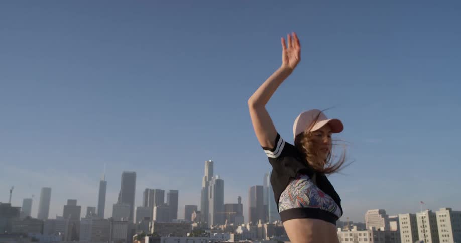 Woman dances on a rooftop in the city
