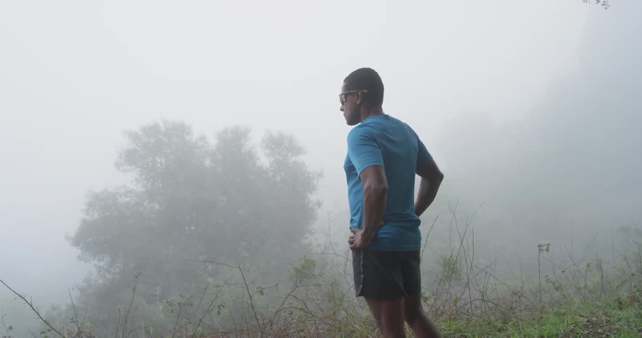 A man stands in a foggy rural area