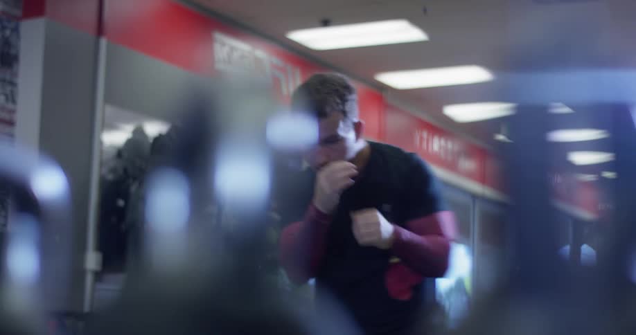 A boxer punches the air in a gym