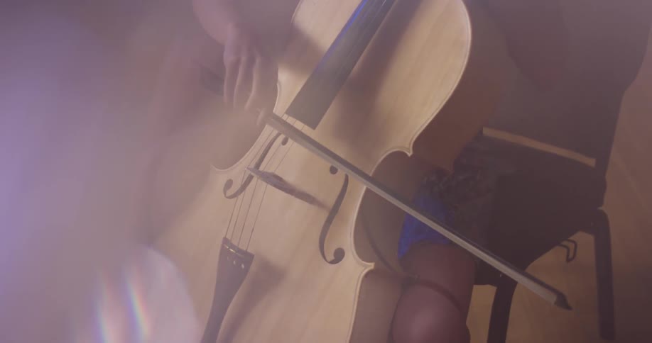 A woman is sitting playing the double bass