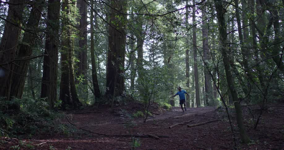 A man is running and jumping in the woods