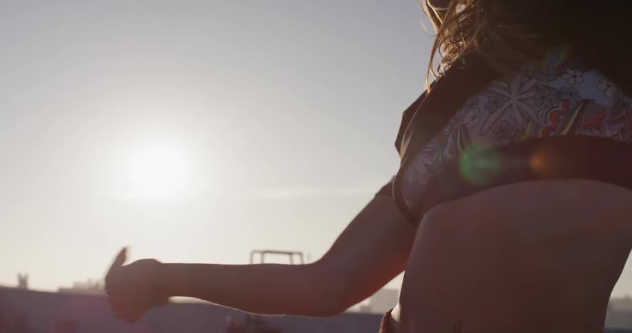A woman dances on a rooftop