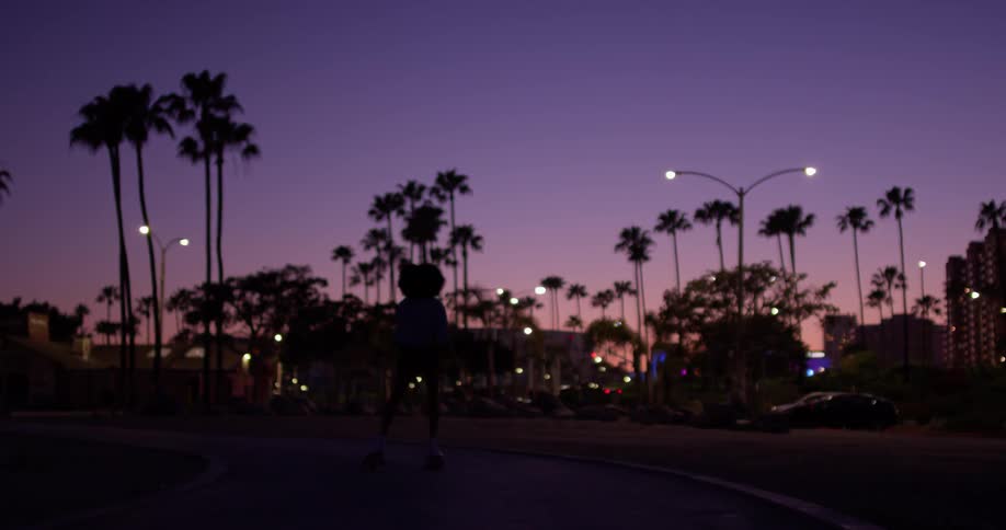 Woman roller skates in the city at night
