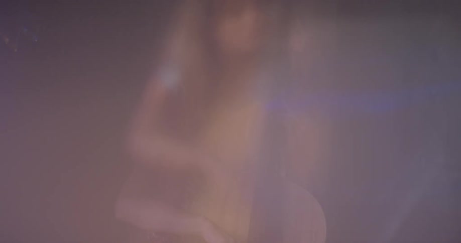 A woman sits and plays the cello