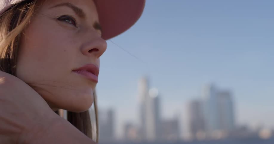 A woman in a pink hat stands atop a rooftop