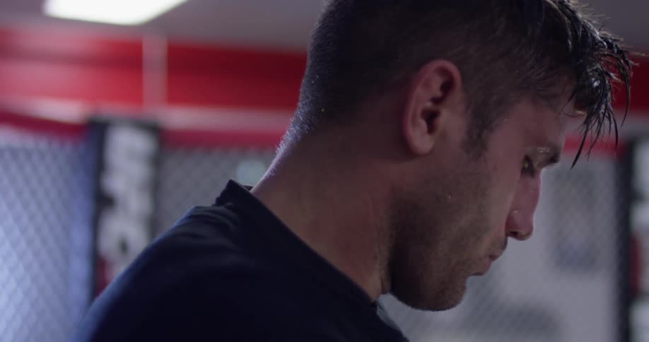 A man breathes heavily in a fighting ring