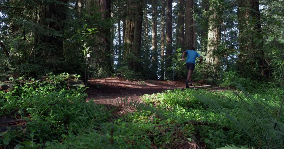 The man runs up the steep trail