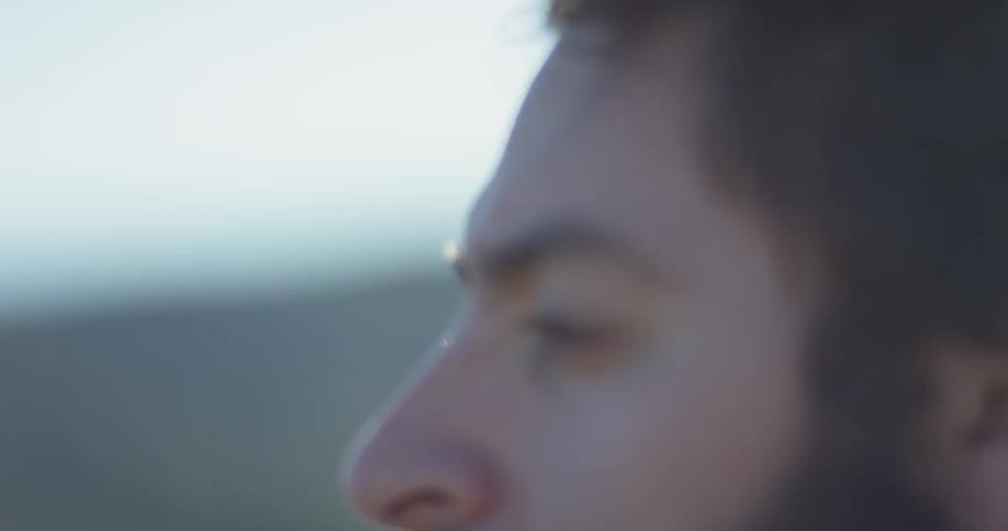 Man stands outside in a field on a sunny day