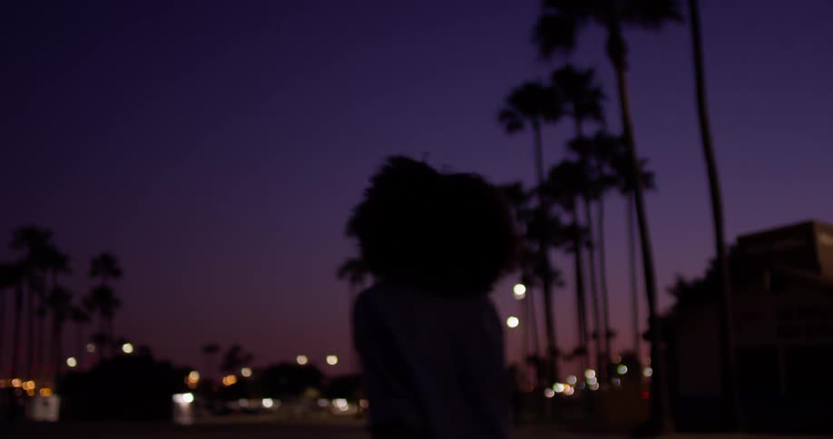A woman roller skates outside at night