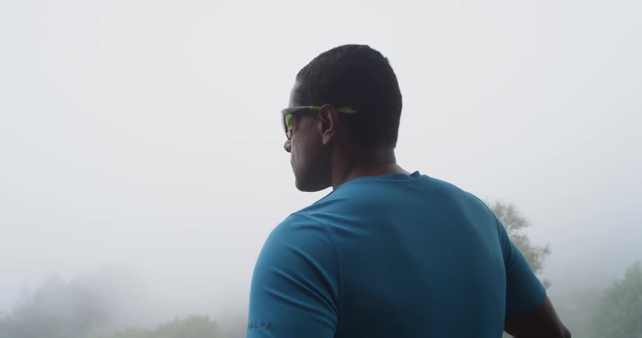 A man stands outside on a foggy day