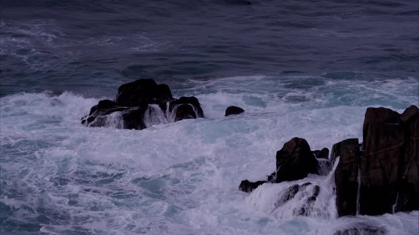 Ocean waves crash into rocks