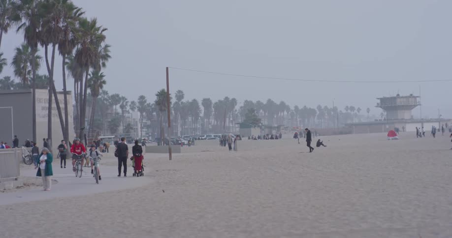People walk and ride bikes on the beach