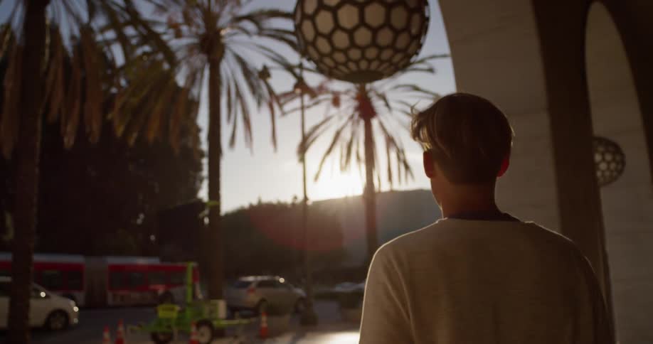 A man is walking through an archway outside in a city in daylight