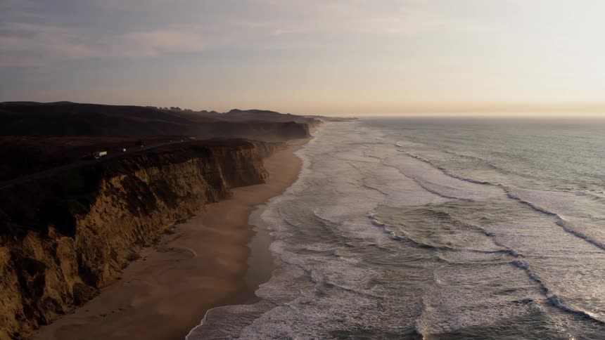 The large waves hit the beach at sunset