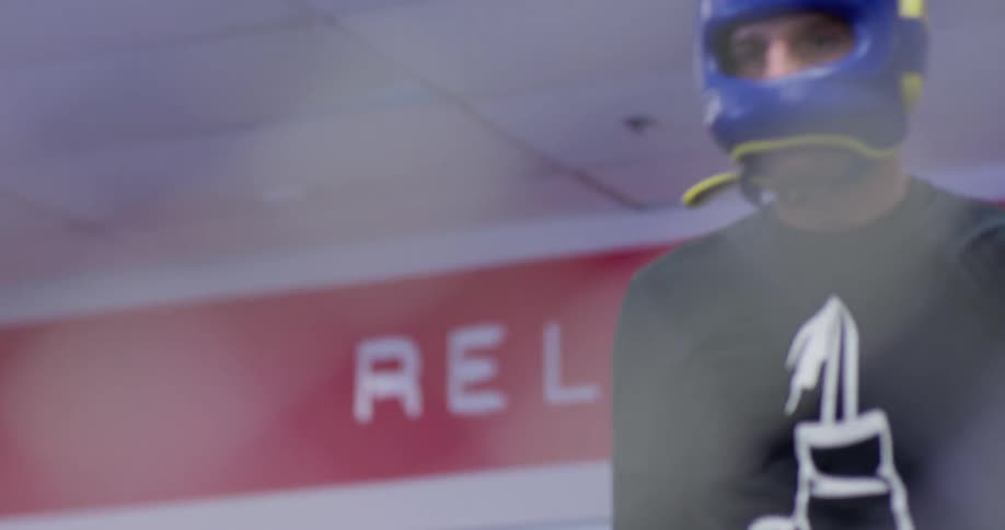 A boxer is circling in a boxing ring before sparring with a partner