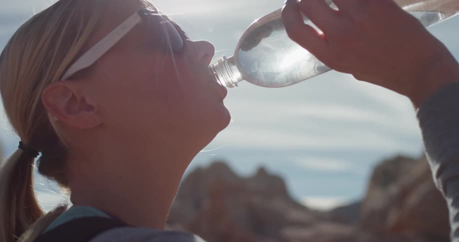 A woman drinks from a water bottle