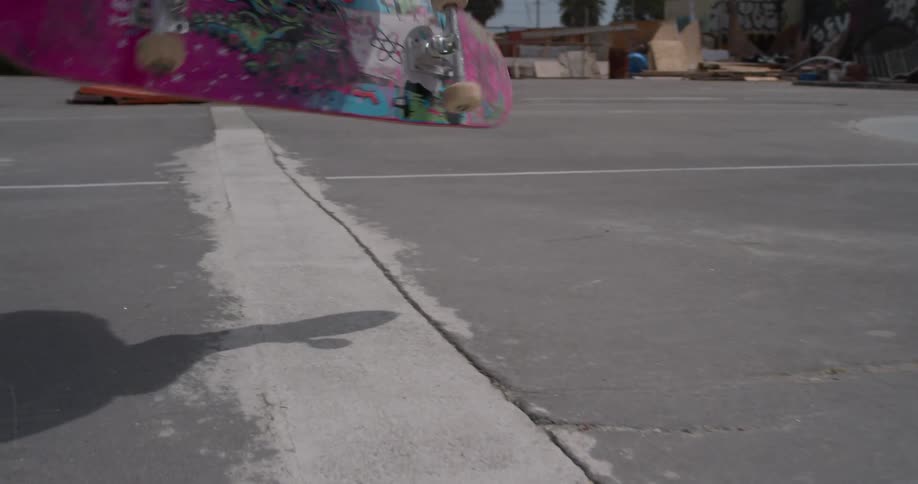 Man flips his skateboard as he rides it in the park