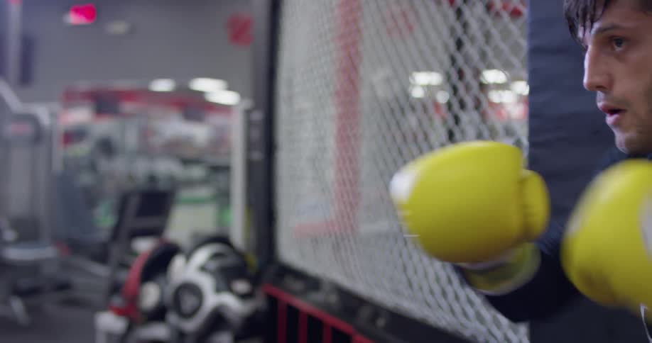 A boxer hits a punching bag at a gym