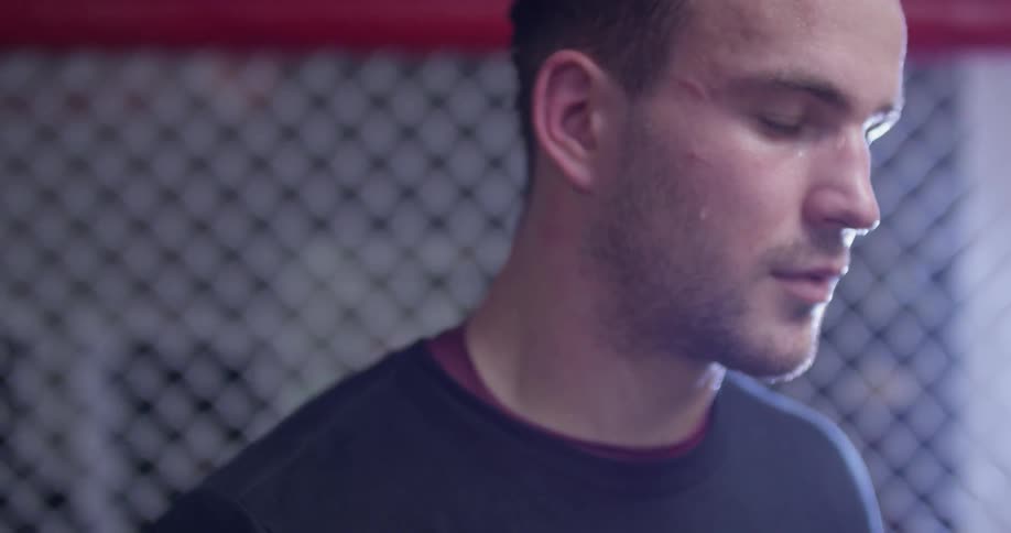 A man stands inside of an mma ring