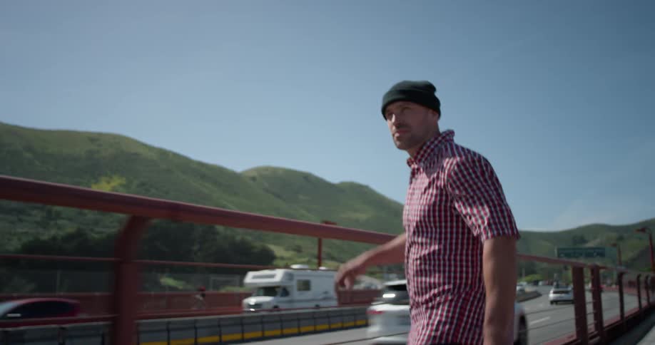 A man skateboards by the busy road