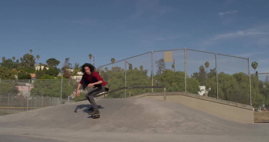 A skateboarder jumps at an outdoor skatepark