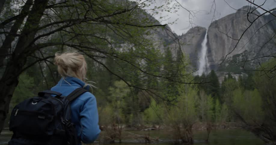 A hiker stops to look around near the mountains