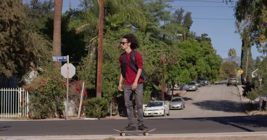 A man skateboards down the street