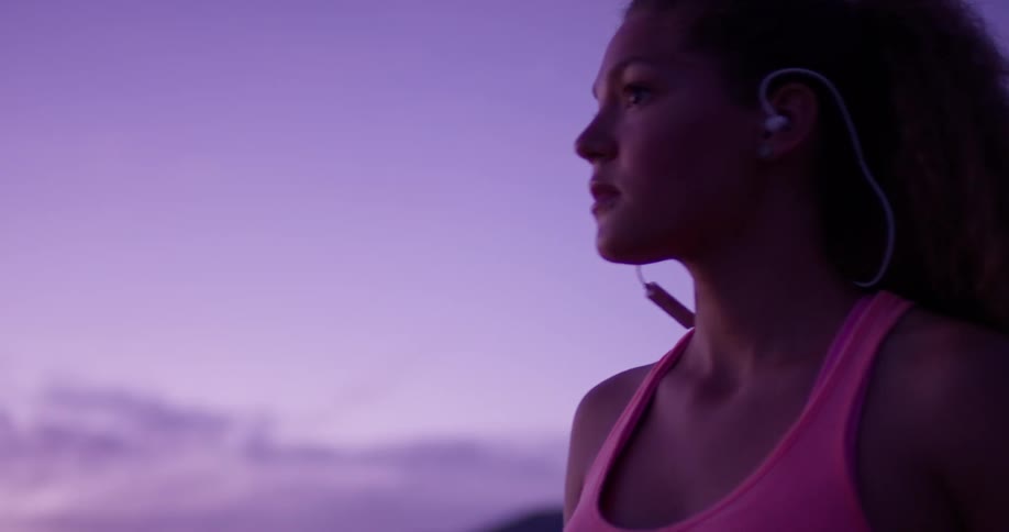 A woman jogs on a rural path at sunset