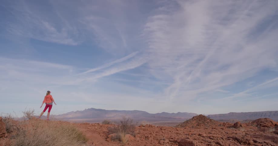A woman is stretching in the desert
