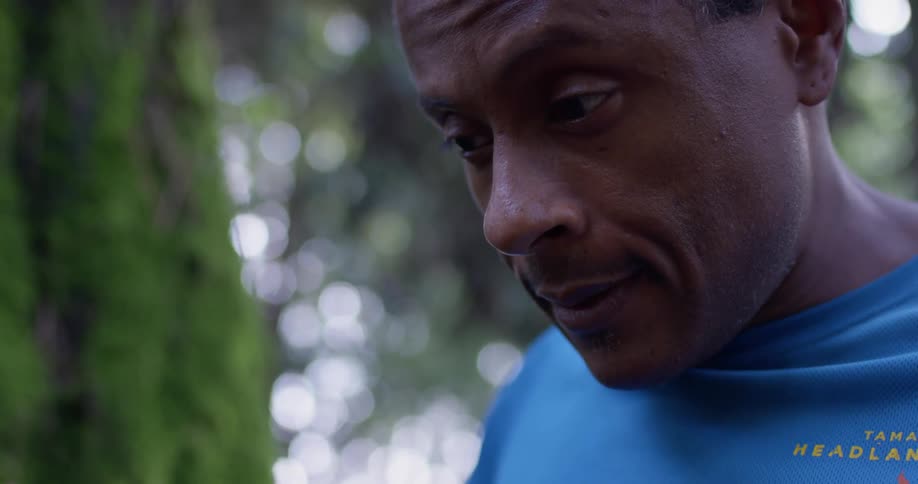 The man looks down in the forest