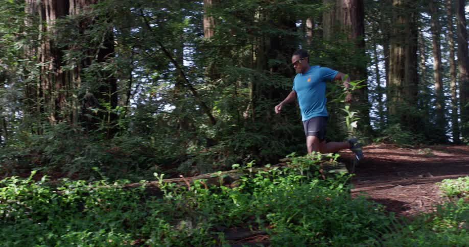 A man jogs downhill on a sunny day