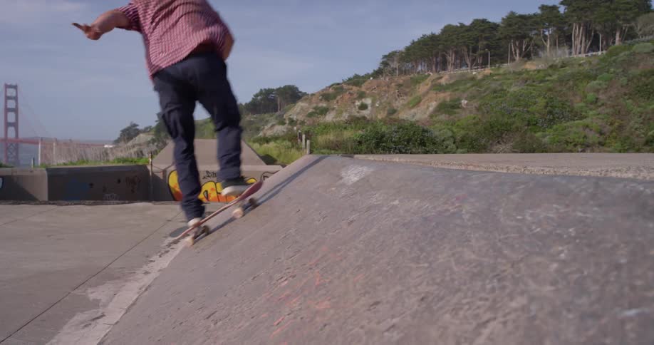 The man rides the ramp in the skate park
