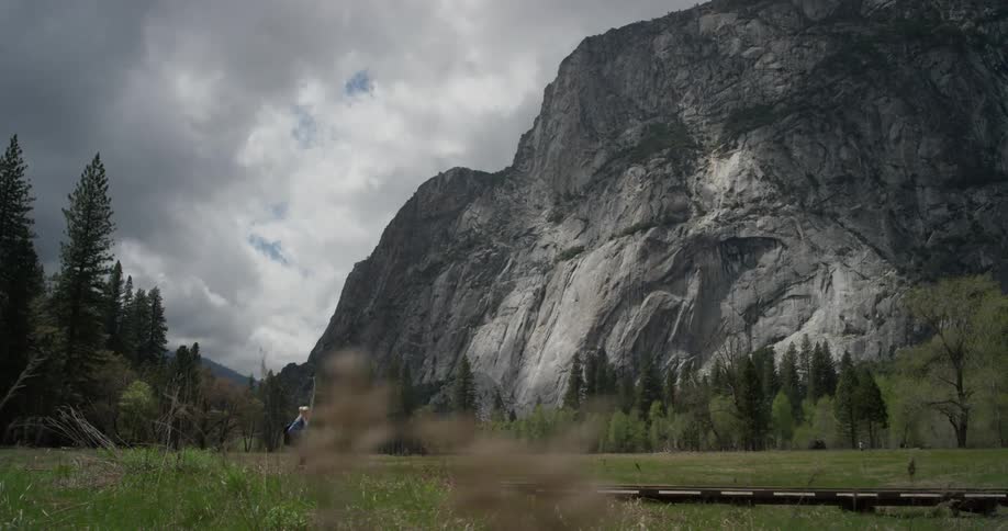 A woman hikes at the base of a mountain