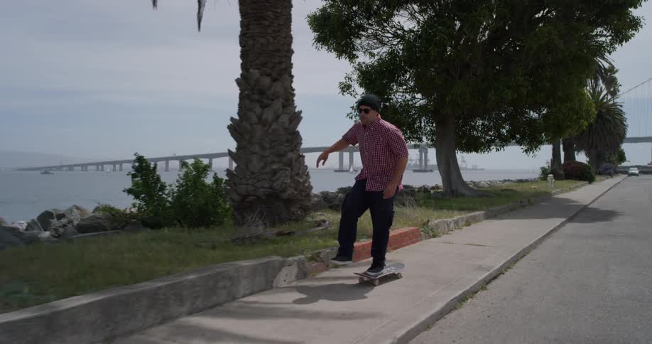 A man skateboards on a sidewalk