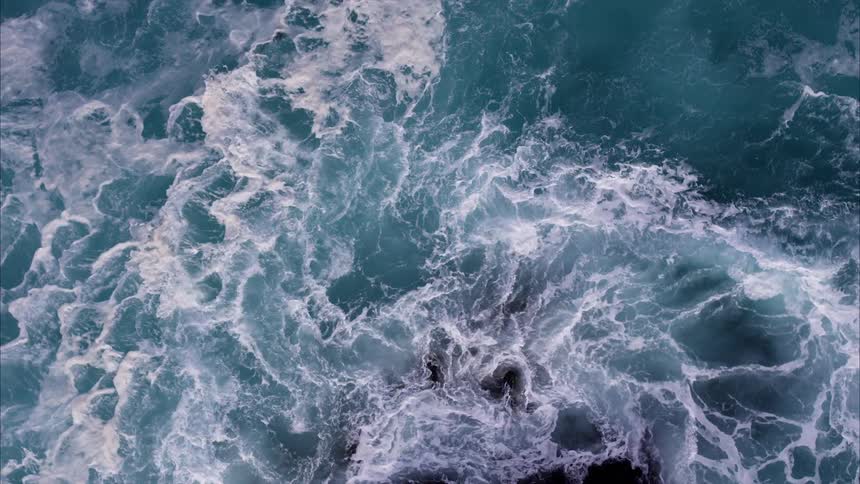 Blue water crashes around below