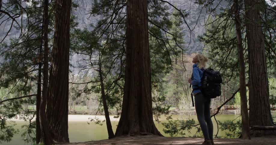 A woman hikes downhill in the forest