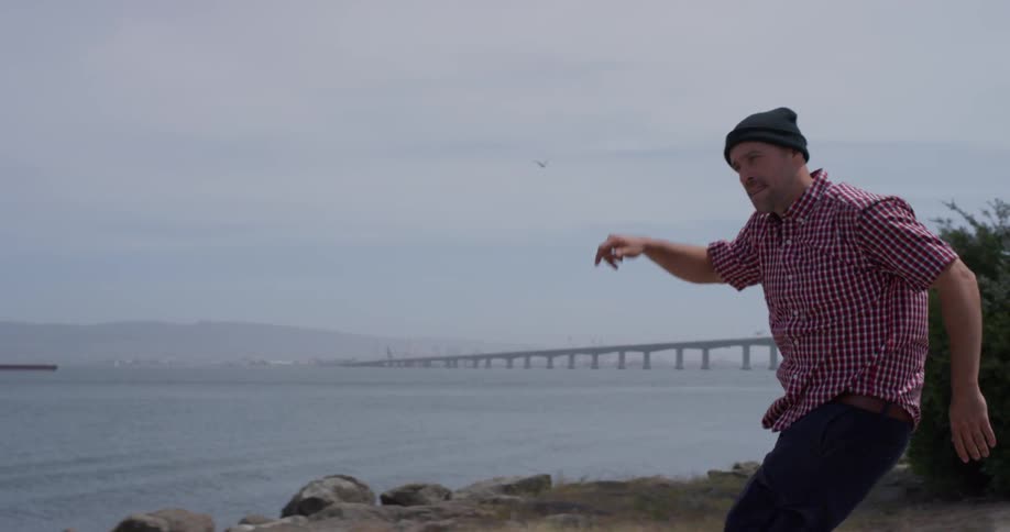 A man skateboards past the cloudy sky