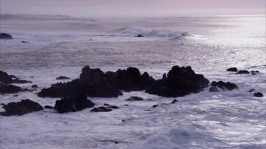 Ocean waves crash into rocks